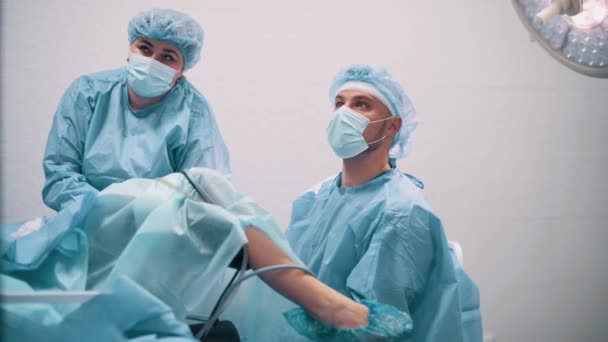 医師は特別な装置を使用して婦人科手術を行います 外科医はスクリーンを見る — ストック動画
