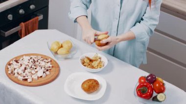 Mutfakta patates soyan bir kadın. Yukarıdan görüntüle.