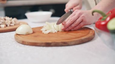 Evdeki mutfakta soğan doğrayan bir kadın. Ellerin yakın çekimi.