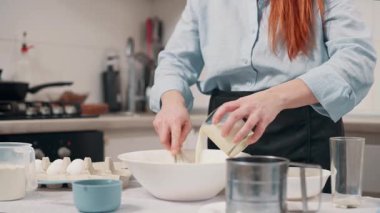 Bir kadın para kazanır. Kadın malzemeleri evdeki mutfakta bir kasede karıştırıyor. Yakın plan..