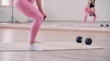 Kız kaldırma yapıyor. Genç, narin kadın spor salonunda antrenman yapıyor..