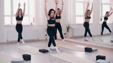 Beden eğitiminde grup çalışması. Jimnastik köprüsü yapan genç atletik kadınlardan oluşan bir takım.