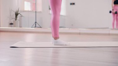 Kız kaldırma yapıyor. Genç, narin kadın spor salonunda antrenman yapıyor..