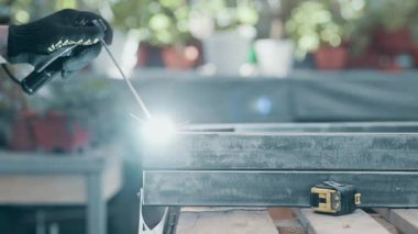 Usta, metal parçaları kaynakla kaynak yapıyor. Yakın plan..