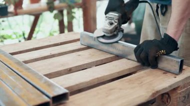 Bir işçi, çelik bir parçanın pasını öğütücüyle öğütüyor. Yakın plan..