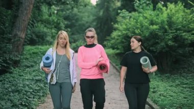 Üç orta yaşlı kadın spor yapmak için parka gider..