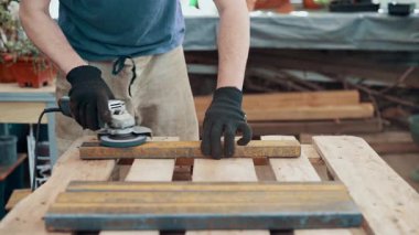 Bir işçi, çelik bir parçanın pasını öğütücüyle öğütüyor. Yakın plan..