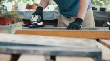 Bir işçi, çelik bir parçanın pasını öğütücüyle öğütüyor. Yakın plan..