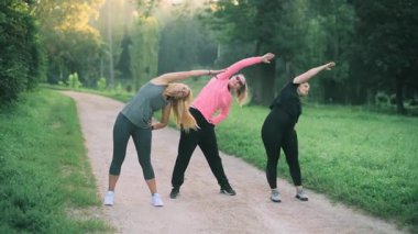 Parkta spor yapan üç orta yaşlı kız arkadaş. Ön görünüm.