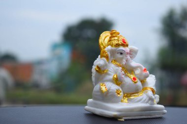 A Ganesh idol on a car dashboard