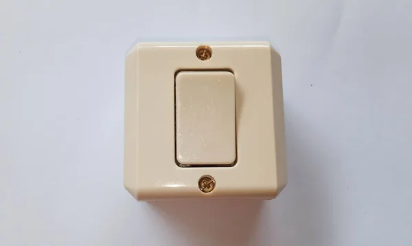 A light switch or saklar, a plastic mechanical switch of white color on a white background.