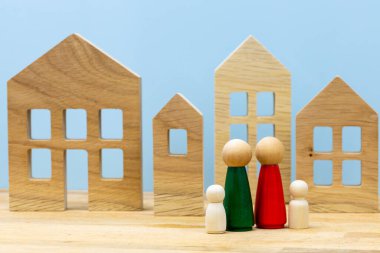 Rüya evi kavramı, tahta figürler, çocuklu mutlu aile yeni bir evin önünde duruyor.