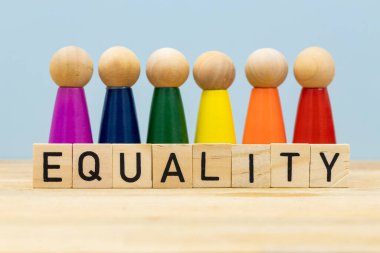 Eşitliğin sembolü, sembolik lgbt renklerinde tahtadan figürler, Eşitlik kelimesinde sıralanmış tahta tabelalar.