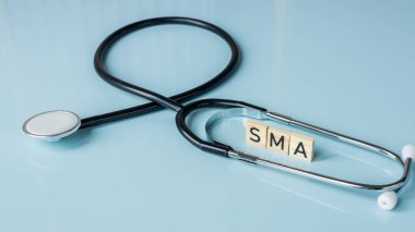 SMA, spinal muscular atrophy, Written on wooden blocks, a rare disease in which, due to a genetic defect, neurons in the spinal cord responsible for muscle contraction and relaxation gradually die