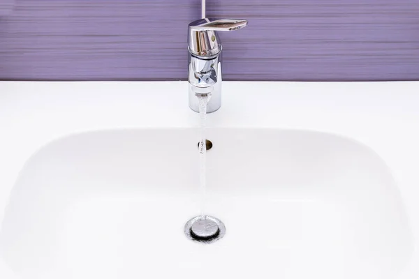 pouring water from the tap in the bathroom, Cost of water consumption, household, saving