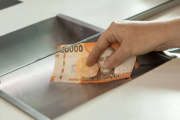 Chile money, Woman standing at the cash desk with cash, Concept, Cash deposit and withdrawal, Financial operations, banking, loans, money exchange, capital investment, financial institution