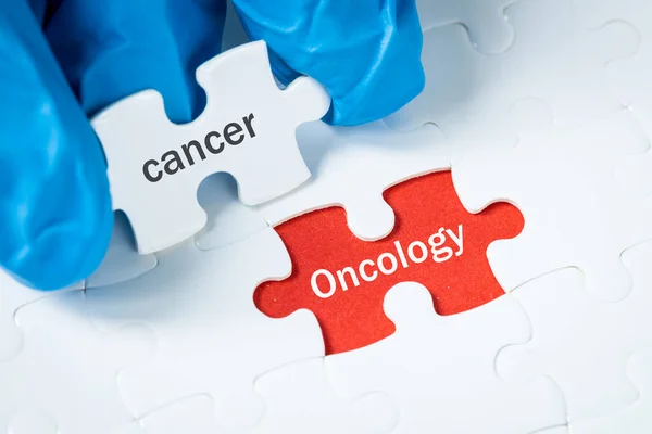 Cancer and oncology, Health concept, Puzzle with the text Cancer unveils a red background with the words Oncology, Preventive examinations, diagnosis, Oncology research promotion