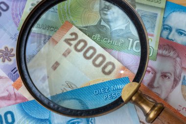 Bir büyüteç, yüksek mezhepler, finansal ve ekonomik konsept üzerinden görülen Şili parası, yakın çekim