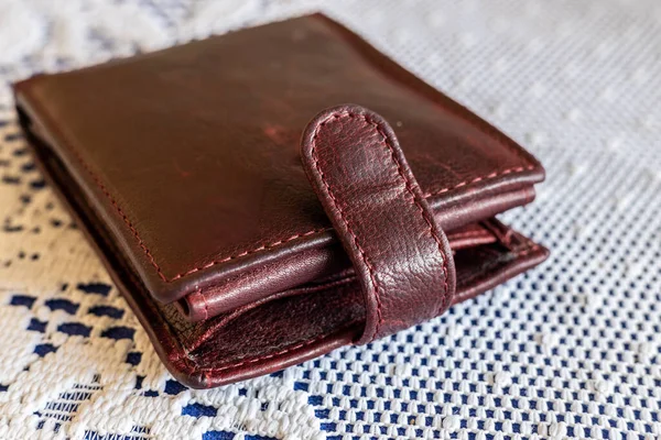 stock image A brown wallet lying on a table on a white tablecloth, The concept of home budget and finance, close up