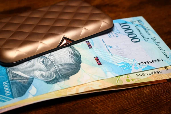 Venezuela money, A bundle of banknotes sticking out of a beautiful gold wallet for cards and money
