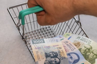 Konsept, Meksika enflasyonu, mağazalarda yükselen fiyatlar, boş alışveriş arabası ve Meksika parası, kapat.