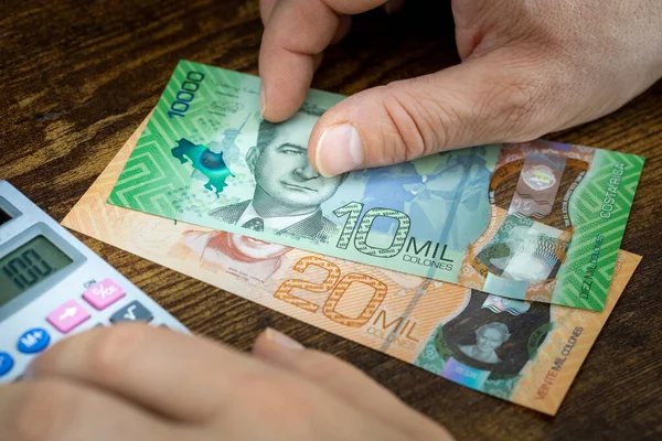Mężczyzna Posiada Kostaryki Pieniądze Jelita Grubego Liczy Wydatki Lub Zarobki — Zdjęcie stockowe