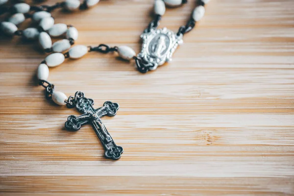 stock image Rosary lying on the table, Catholic cross