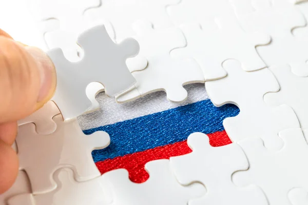 puzzle reveals the flag of Russia, the concept of the economic and social situation of the country