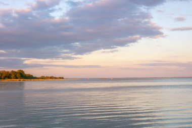 Macaristan 'daki Balaton Gölü' nde gün batımı, sakin su yüzeyi, güzel bulutlar, kavram, tatil manzarası.