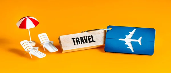木製のブロック 休暇のコンセプト 航空機用荷物タグ サンラウンジャーと傘ミニチュア 美しい黄色の背景 パノラマに旅行を書き込み — ストック写真