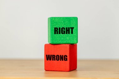 two wooden blocks red with the word wrong and green with the text right The concept of making the right decisions clipart