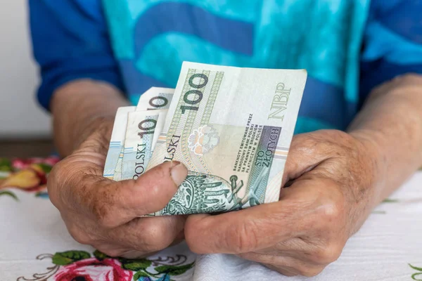 stock image An old woman holds 100 Polish zloty banknotes in her hands, Polish money, Pensioners finance concept