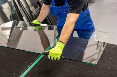 Camcı cam kapağı özel cam kesim masasına koyar. Cam fabrikası.