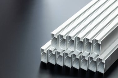 Güzel bir siyah arkaplanda alüminyum profiller, alüminyum elementler dizileri, inşaatlarda kullanılan malzeme, hafif alüminyum yapılar, iç kapaklar, kapılar ve çerçeveler