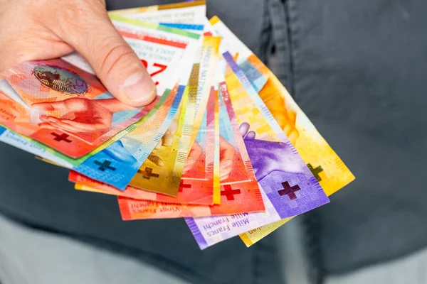 Switzerland money, a bundle of francs held in hand financial concept