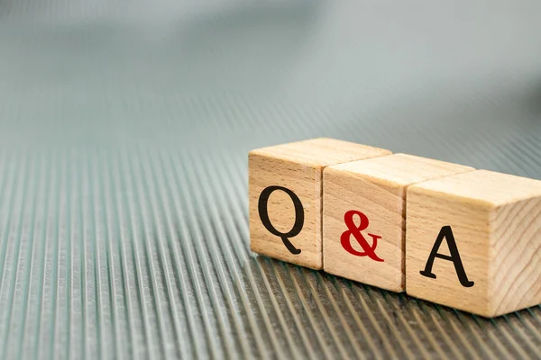 Q and A, Questions & Answers symbol written on wooden blocks, business concept