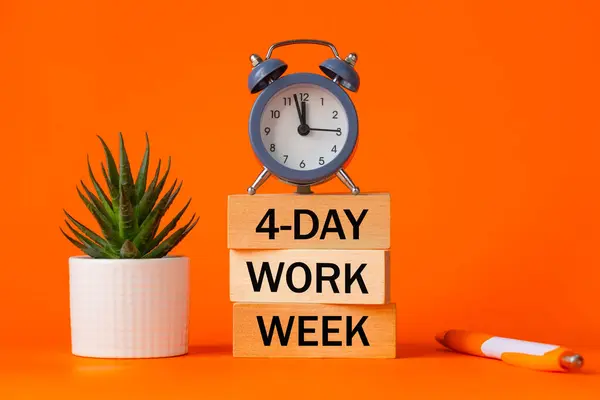 Symbol of a 4-day working week. Desk with wooden blocks with the words 4-day work week, seculant, pen, beautiful orange background. Copy space. Business concept, change from 5 to 4 day work week