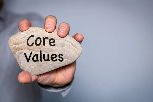 Our core values symbol,  Businessman holds in his hand a stone with the principles of his company engraved on it,  Business and Our core values concept. Copy space.