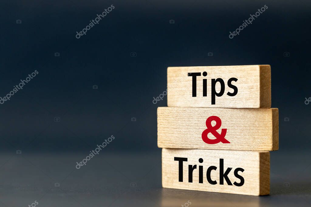 Wooden blocks with the words Tips and Tricks. Tips and tricks icon. Beautiful blue navy background. Business concept and business consulting. Copy space.