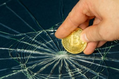 Kırık cam ve parmaklarda tutulan Bitcoin, Kripto para piyasası çökmesi, Bitcoin zayıflama, sanal para birimleri