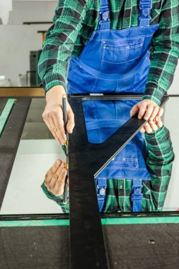 Bir camcı özel bir masa üzerinde kalın cam keser, kavram, cam işçiliği, dikey fotoğraf