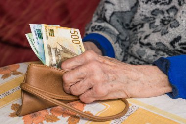 Norveçli küçük bir miktar kron, bir emeklinin elinde, Finansal konsept, Norveç 'teki yaşlıların sorunları