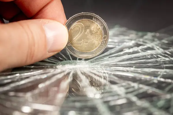 European money, 2 euro coin reflecting in broken glass, Financial concept, European currency, Rate drop, analysis and forecasts for the euro zone
