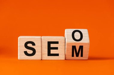 SEO sözcüğünün SEM 'de değişmesi, güzel turuncu arkaplanda ahşap küplerle yazılması, Arama Motoru Optimizasyonu ve Arama Motoru Uygulaması kavramı, Boşluk Kopyalama