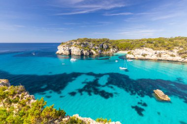 Minorca sahilindeki Macarella plajı, güzel deniz manzarası, beyaz uçurumlar, turkuaz deniz, İspanya 'da tatil için güzel bir yer.