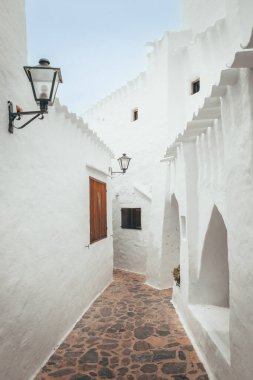 Majorca, İspanya 'daki büyüleyici Binibeca kasabasındaki beyaz evler, dikey fotoğraf.