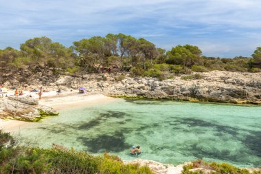 Talaier sahili manzarası, güzel gök mavisi suyu, güneşlenen insanlar, yatlar, Avrupa 'nın en güzel plajlarından biri. İspanya 'daki Menorca Adası