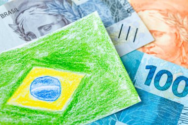 Brezilya finans, pastel boyalı Brezilya bayrağı ve Brezilya reais banknotları, konsept, mali eğitim ve öğrenim para yönetimi