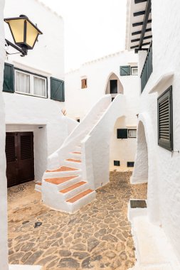 Menorca 'daki güzel Binibeca kasabası. Dar sokaklar ve ahşap elementli beyaz duvarlar, İspanya 'da Akdeniz mimarisi