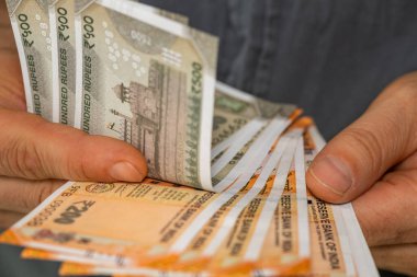 Hindistan parası, Adam Hint rupileri sayıyor, yakın plan çekimleri ve banknotlar. 200 ve 500 'lük banknotlar halinde nakit.